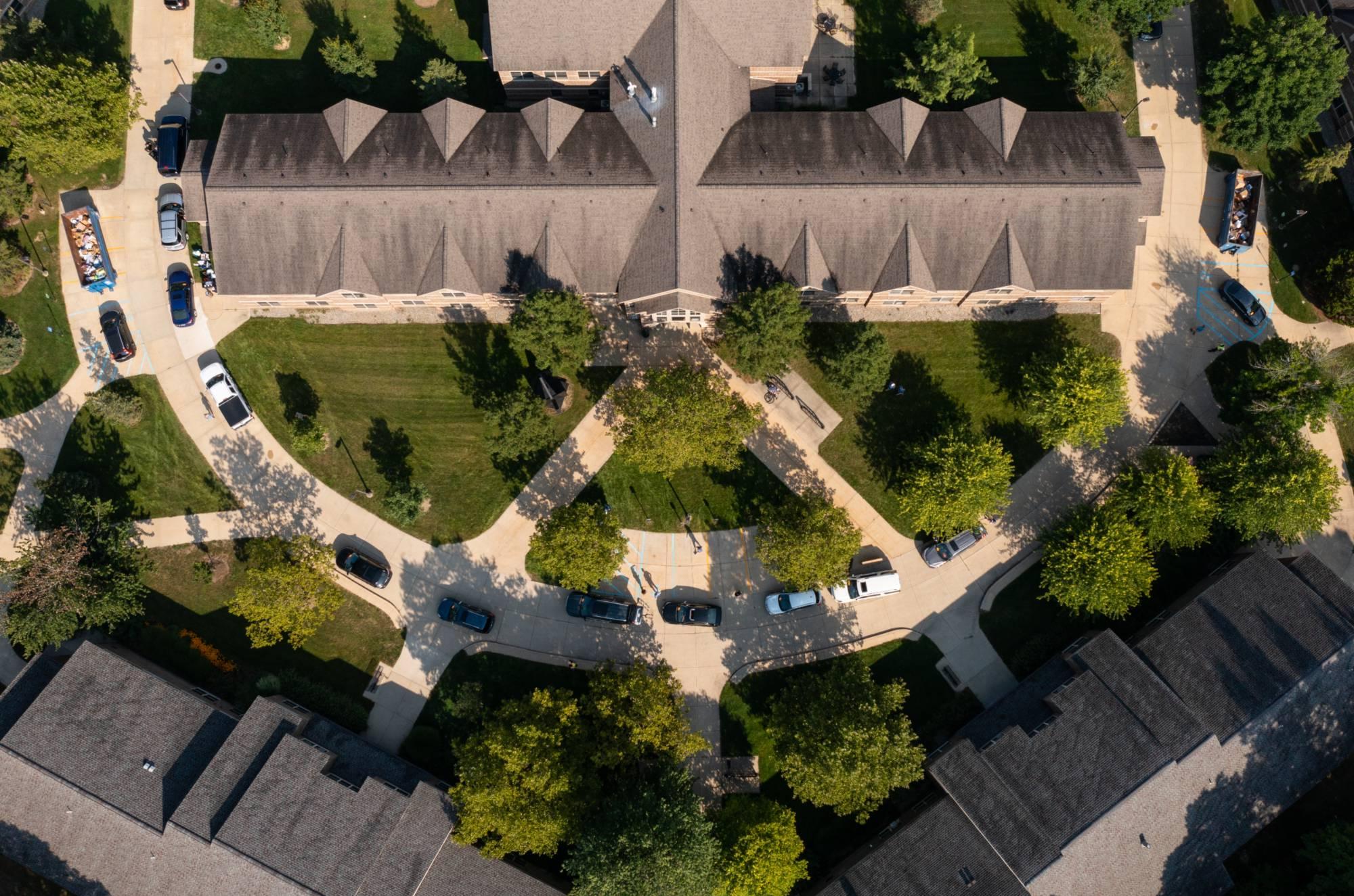 An overhead image of cars lined up outside of a living center for move in